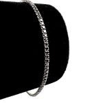 Brățară Tennis negru-argintiu, cu un design de zale, este afișat elegant pe un suport de catifea neagră pe un fundal alb.